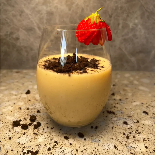 A creamy snack topped with strawberry and chocolate crumb